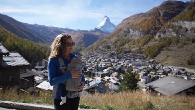 在瑞士阿尔卑斯山徒步旅行时，母亲用胸前背包背着婴儿
