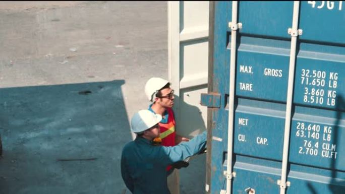 仓库工人和工程师检查集装箱。