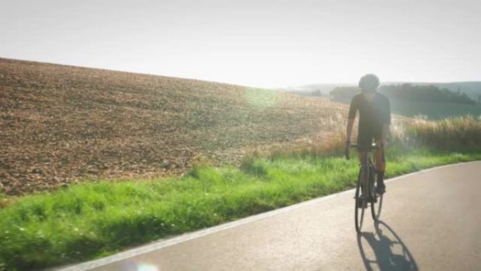 专注于运动的专业自行车手女子骑着自行车离开马鞍。公路自行车概念。女运动员推动踏板，爬坡。时尚的骑自行