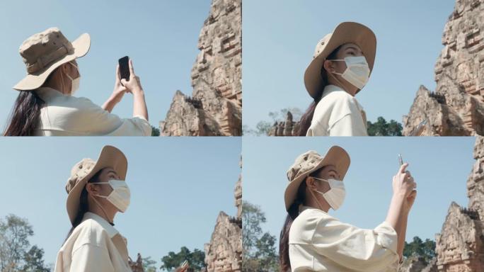 亚洲妇女在疫情期间独自旅行。戴防护口罩保护自己。