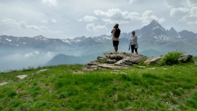 徒步旅行夫妇到达山顶并欣赏山景的鸟瞰图