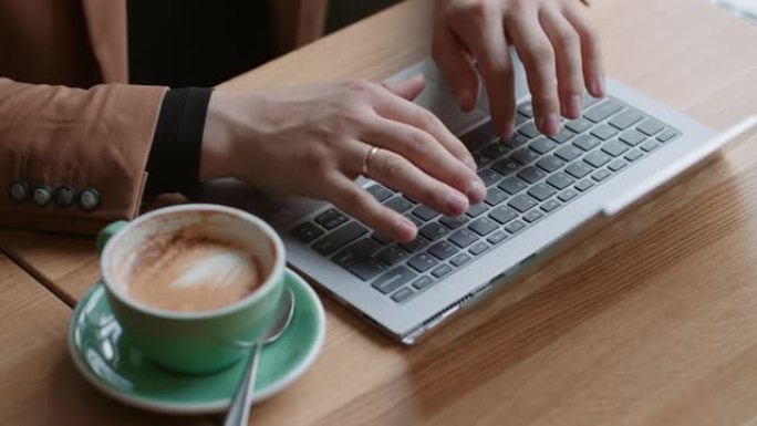 男性手放在现代笔记本电脑的键盘上，从顶部特写镜头，上班族正在发送信息