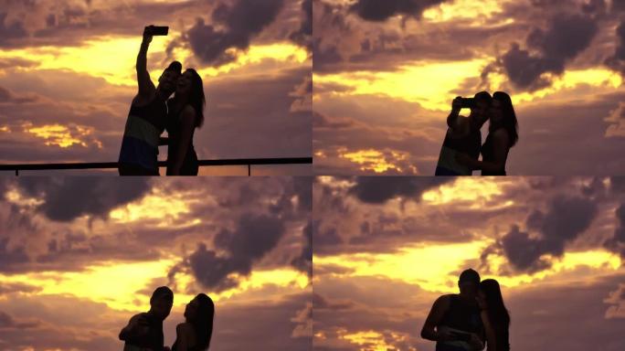 情侣在一个可以看到日落海景的露台上。自拍