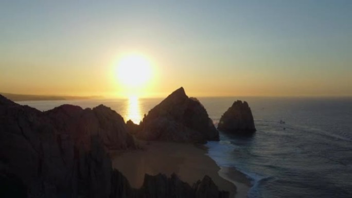 空中无人机在日出时拍摄的岩石悬崖边海滩