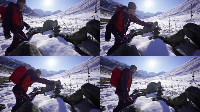 男子在雪山上堆放石头