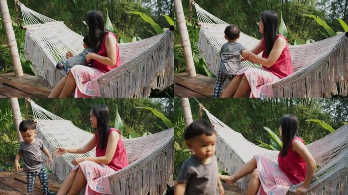 亚洲母亲和她的儿子坐在吊床上放松