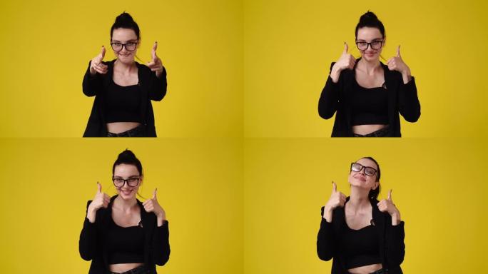 4k慢动作视频，一个女孩指着相机，在黄色背景上竖起大拇指。