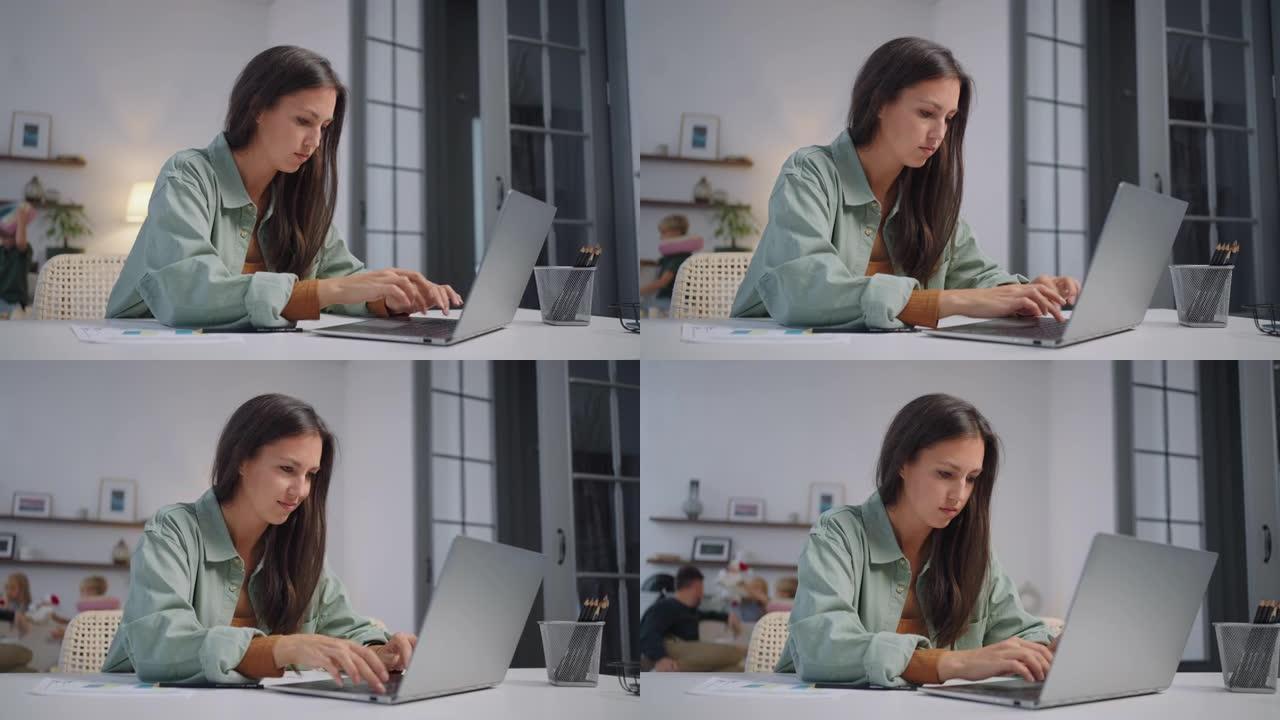 一名女商人在笔记本电脑上远程工作，并在家庭在后台唱歌时在网络摄像头上显示图表。忙碌的女商人。小型企业