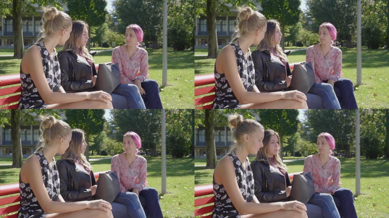 一群年轻妇女坐在公园的长椅上聊天