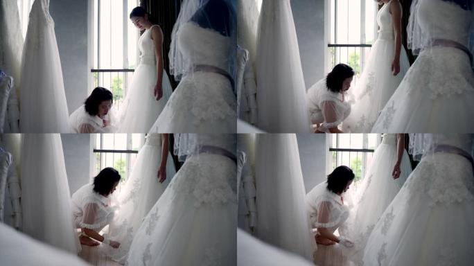 亚洲女裁缝在身体周围剪裁新娘的礼服。