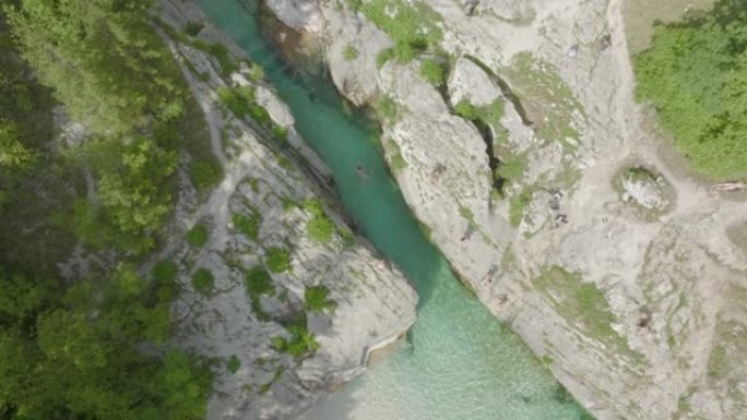 空中无人驾驶飞机可以看到清澈的高山河流，人们跳进海岸，游泳和放松