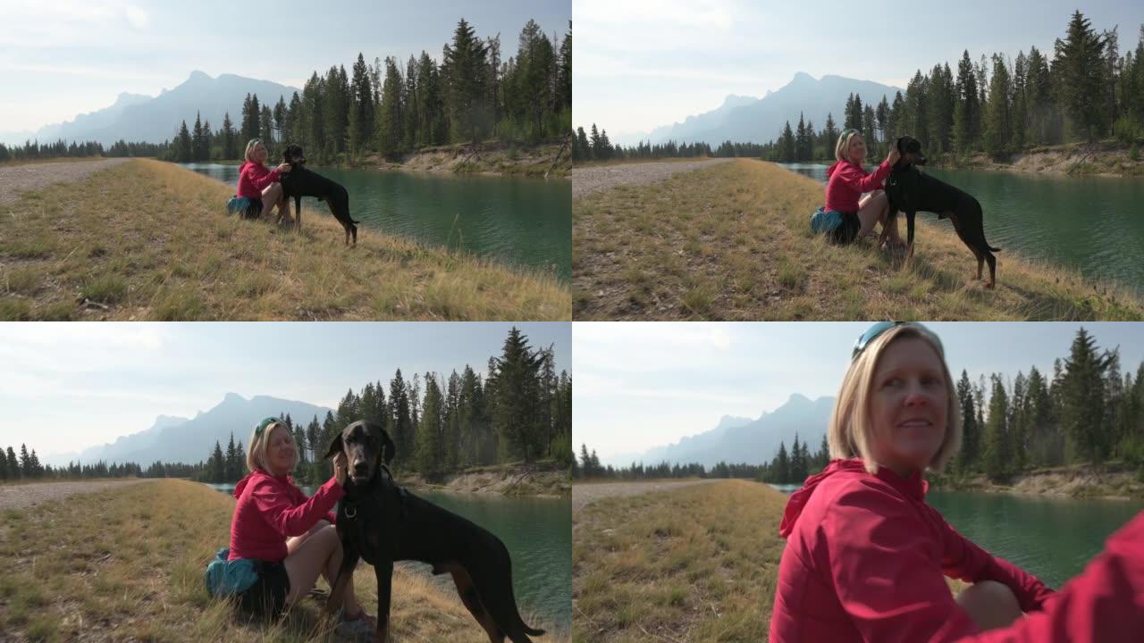 女人在山上与宠物狗一起享受户外时光