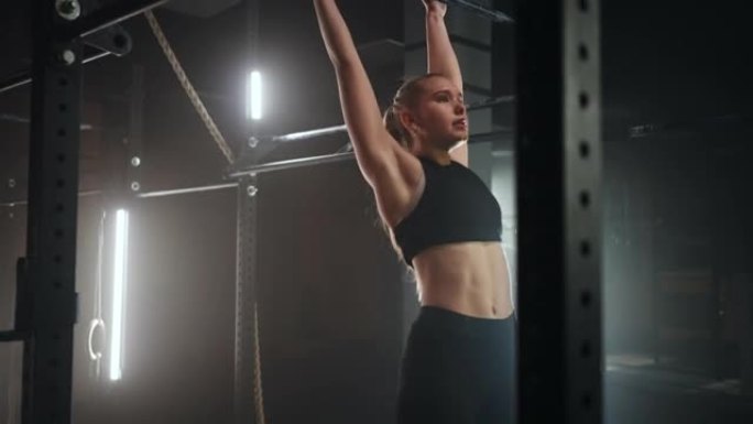 一名女子在体育馆表演攀岩绳的全长广角镜头。体育运动健康成分。交叉健身。一个意志坚定的女运动员正在攀爬
