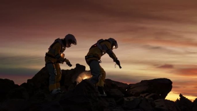 火星上的两名宇航员。夜间探索外星球。攀登岩石山