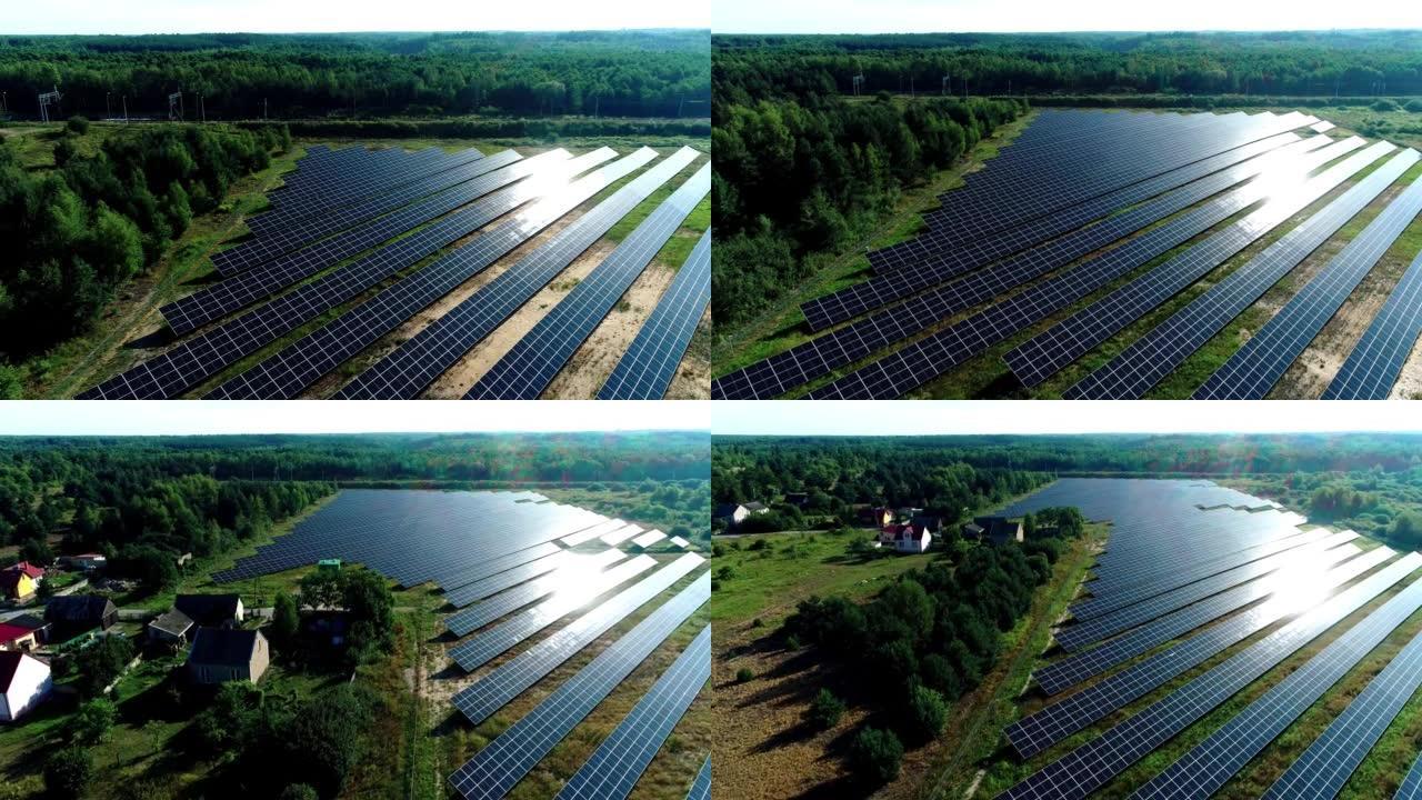 太阳光下太阳能电池板农场 (太阳能电池) 的鸟瞰图。被树木和居民区包围