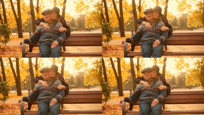 高级男子在城市公园等他的女儿。女儿在他们的会议上拥抱他。美丽的秋天自然