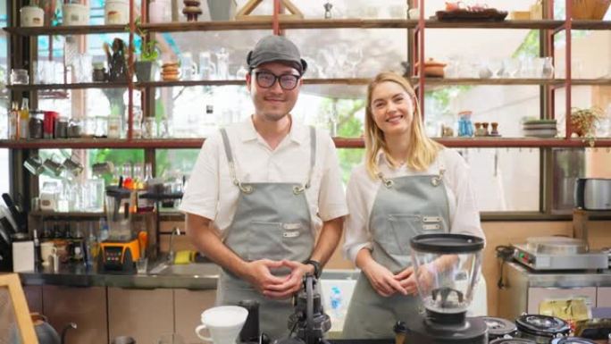 迷人的咖啡师男女服务员在咖啡馆工作的肖像。年轻的商业企业家穿着围裙，在咖啡店餐厅咖啡馆充满信心地看着