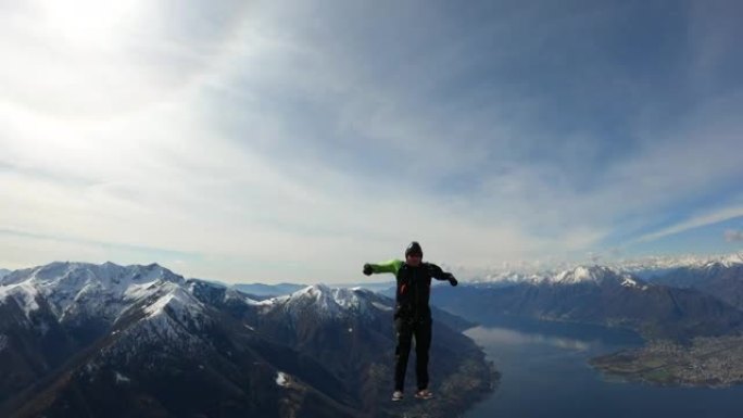 跳伞运动员降落在乡村景观上方的晴朗天空中