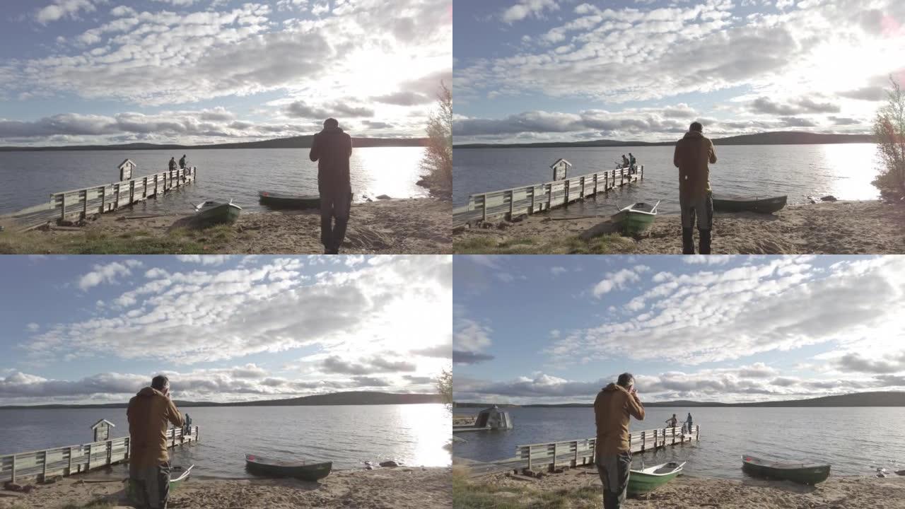 摄影师在湖附近的码头上拍摄山地自行车上的男人和女人