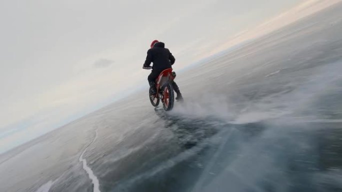 摩托车手在冰上骑行。无人机的动态飞越