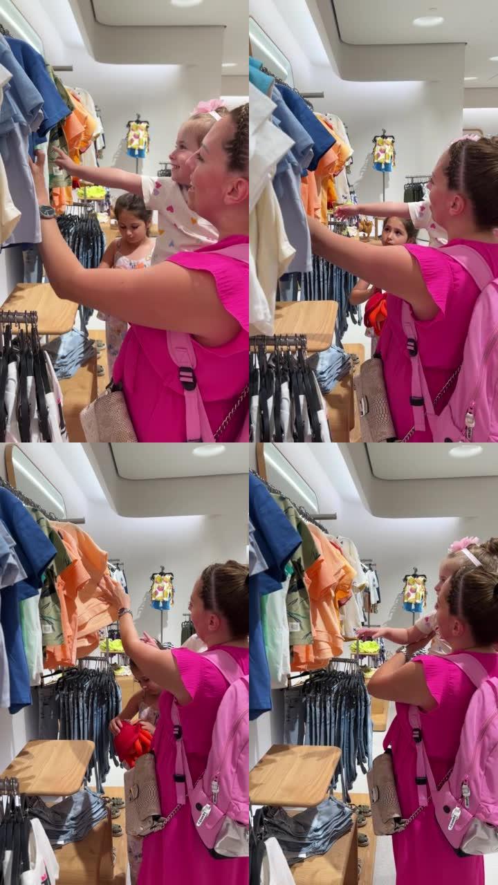 母亲在服装店购物时抱着蹒跚学步的女儿