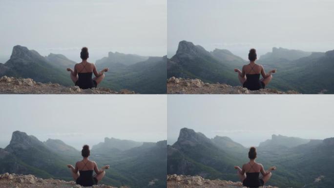 非洲民族妇女在悬崖顶上沉思，看着山景
