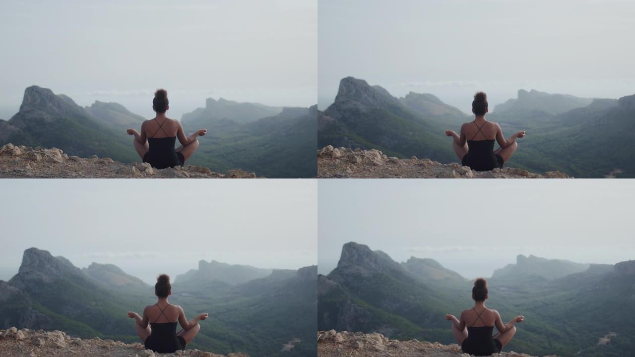 非洲民族妇女在悬崖顶上沉思，看着山景