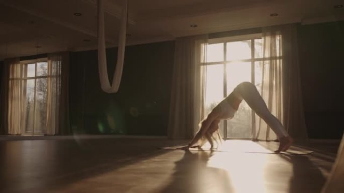 在家锻炼的健康女性在房间里练习瑜伽姿势享受早晨健身锻炼