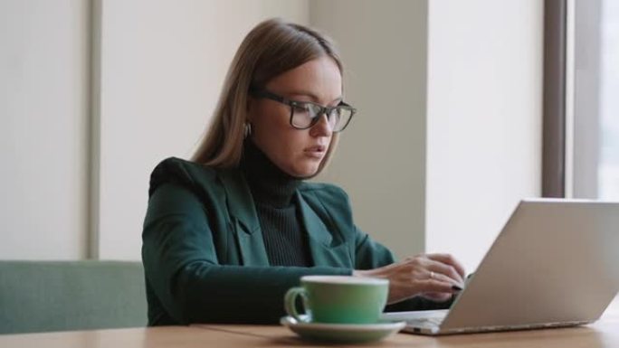 认真的女人正在咖啡馆或办公场所，律师或房地产经纪人中使用笔记本电脑