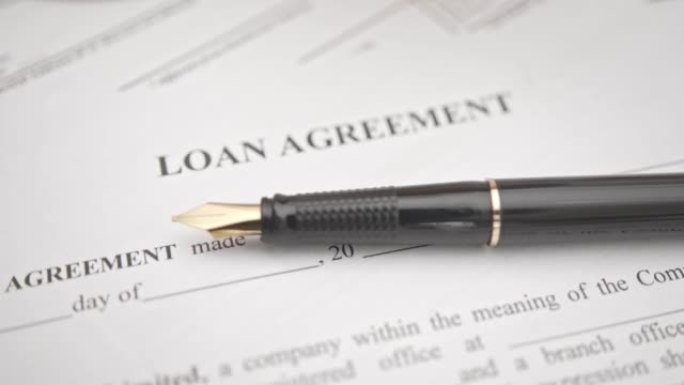商业贷款协议或法律文件概念: 钢笔上的贷款协议纸表格。