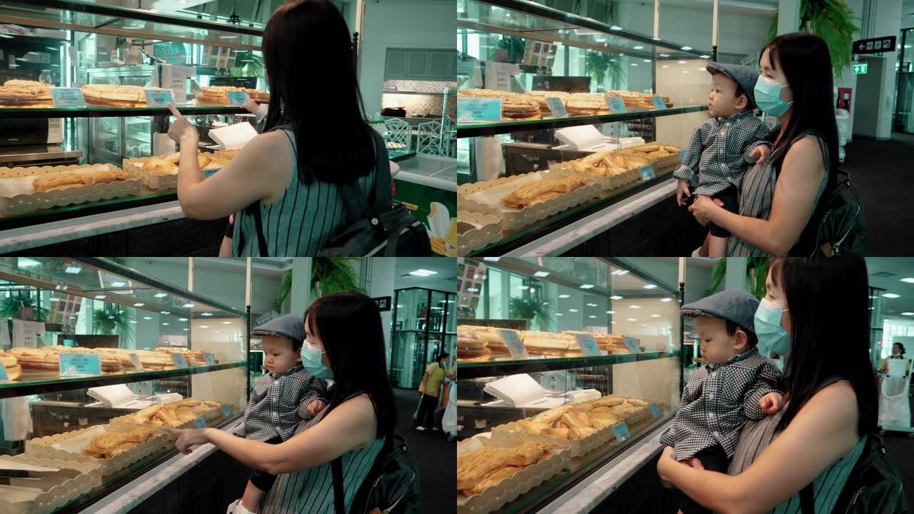 迷人的年轻母亲正在机场选择面包