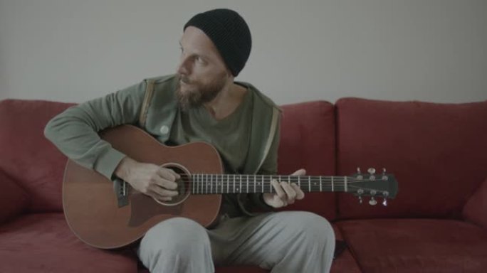 原声吉他手在沙发上弹吉他: 家庭生活