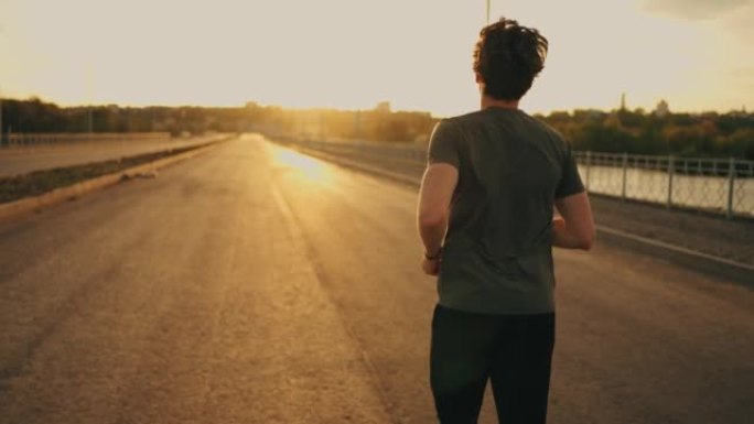 男运动员在日出或日落的道路上跑步，运动员在户外训练，准备马拉松