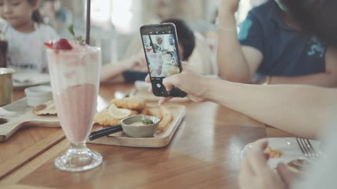 女人使用智能手机在咖啡店拍照