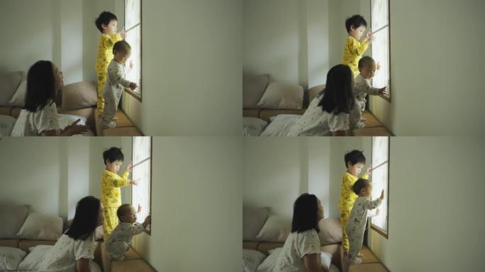快乐的亚洲蹒跚学步的男孩在早上醒来后与小弟弟一起玩耍