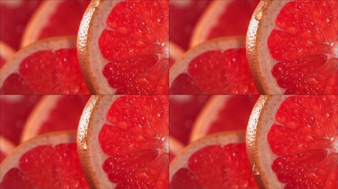 一滴水顺着成熟多汁的柚子片的表面流下来。慢动作4K