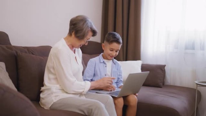 快乐奶奶和小孙子一起学习使用笔记本电脑，技术