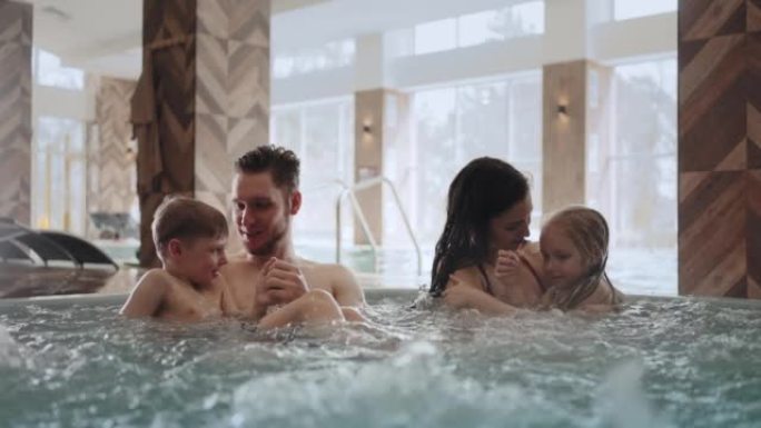现代化的温泉中心，带热水的幸福家庭在洗澡时放松