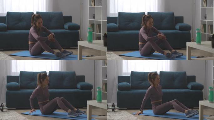 苗条的运动女人坐在地板上，看着健身追踪器，健康生活方式的小工具，家庭训练