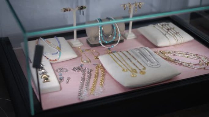 在珠宝店的室内陈列柜上摆放着五彩缤纷的珠宝。在灯光下的室内昂贵的漂亮配件。慢动作。