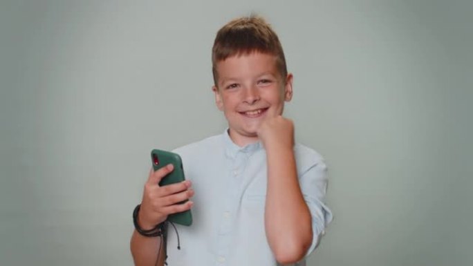 快乐兴奋的男孩用手机说哇是的，发现了大赢家新闻做赢家手势