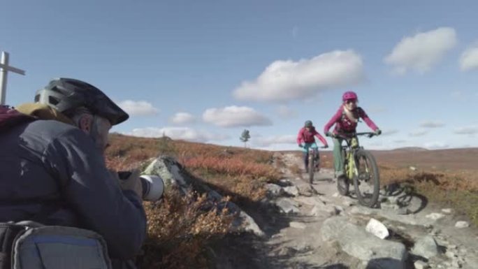 摄影师拍摄了一对山地自行车夫妇在广阔的土地上骑行