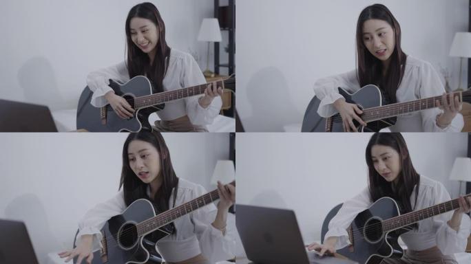 微笑的年轻女子在家学习吉他