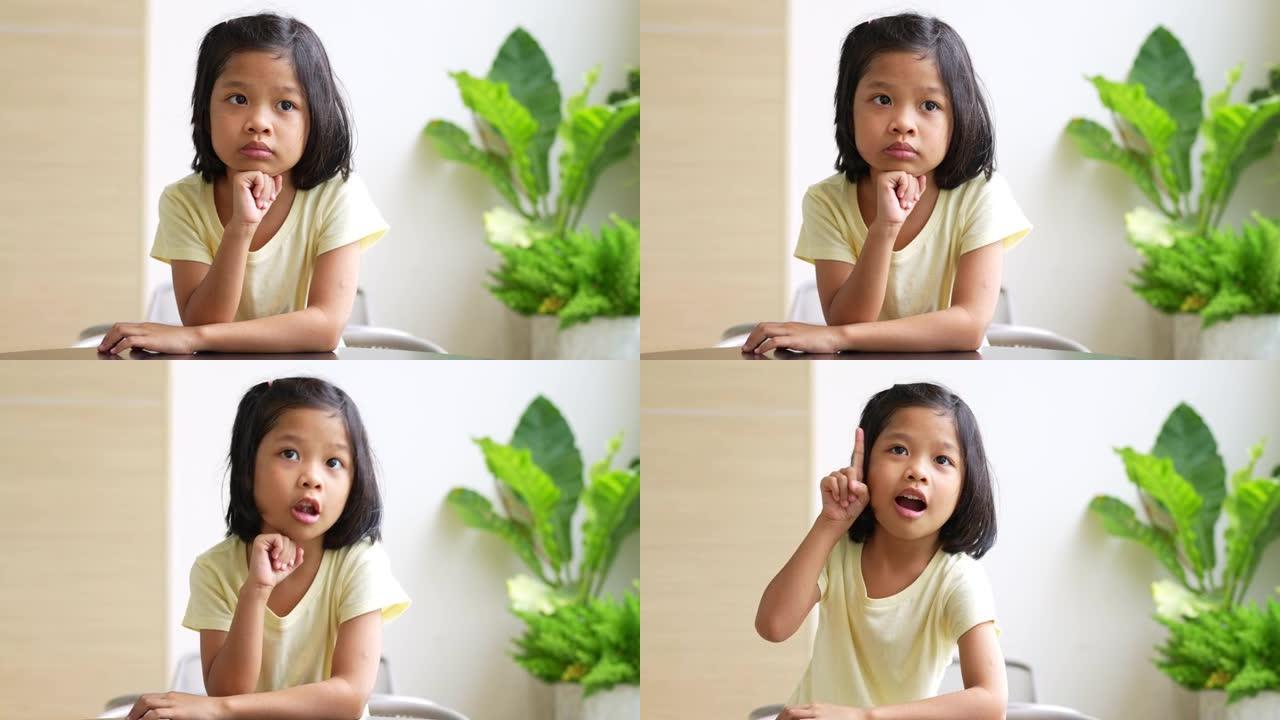 亚洲5岁儿童的肖像，并收集头发并将手放在下巴上并做出思考的姿势，她是幸福，青春的光辉，教育理念