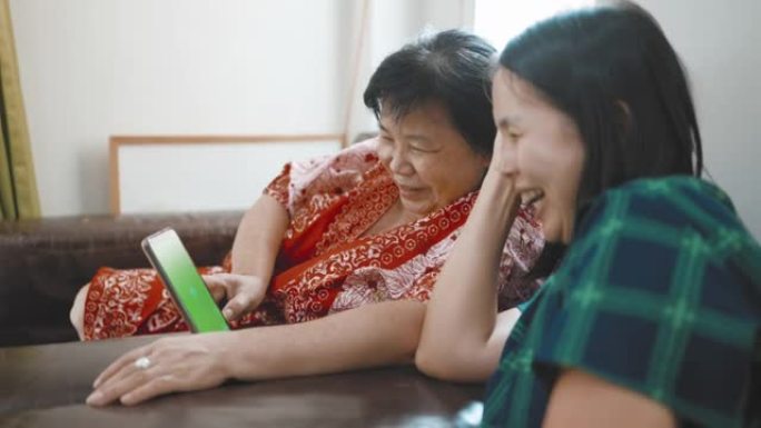 老年妇女和她的女儿使用数字平板电脑