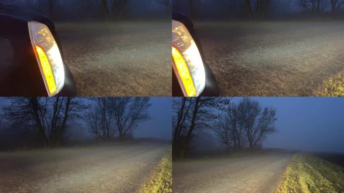 傍晚在乡村道路上雾中汽车前灯发出的光。