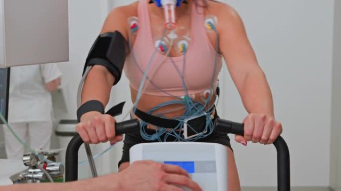 LD女运动员在诊所的自行车测力计上进行心肺压力测试