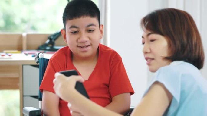 女性护理员在家帮助残疾男孩 (10-11岁) 接受智能手机教育