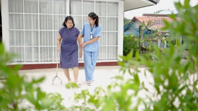 女护士帮助老人用拐杖走路，进行物理治疗。