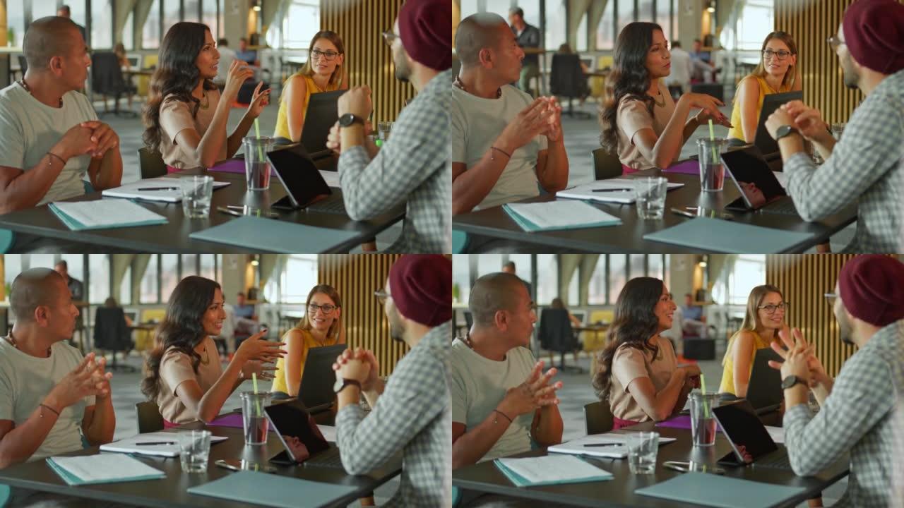 一个女人在同事空间的桌子上与她的团队交谈